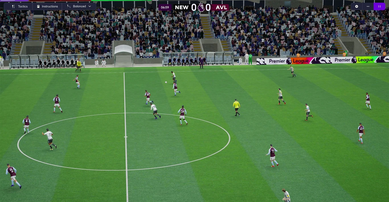 Football Manager 26 Mecz piłki nożnej pomiędzy drużynami w białych i bordowo-białych strojach na stadionie, widoczni zawodnicy w trakcie gry, sędzia na środku boiska, tłum kibiców na trybunach i banery reklamowe wokół murawy.