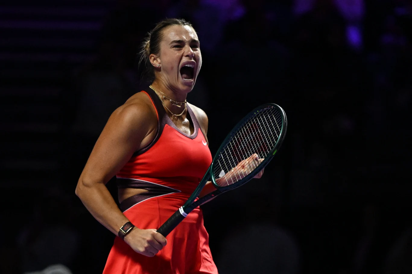 Aryna Sabalenka w trakcie WTA Finals 2025 Tenisistka w czerwonej sukience z rakietą w dłoni wyraża silne emocje i triumf, będąc na korcie, najprawdopodobniej po wygraniu ważnej wymiany lub punktu.