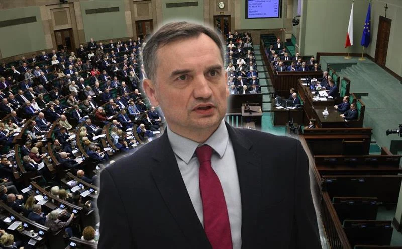 Sejm wydał zgodę na uchylenie immunitetu Zbigniewa Ziobry ws. wszystkich 26 zarzutów Polityk w garniturze z czerwonym krawatem na tle sali plenarnej polskiego parlamentu, wypełnionej parlamentarzystami podczas obrad, w tle widoczne flagi Polski i Unii Europejskiej.