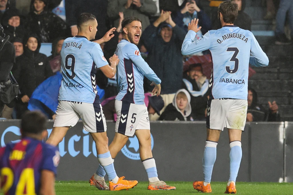 Sergio Carreira (w środku) na bramkę z rzutu karnego "Lewego" odpowiedział błyskawicznie Piłkarze drużyny w błękitnych strojach świętują zdobycie gola na boisku podczas meczu piłkarskiego, wokół nich widoczna jest radosna publiczność na trybunach.