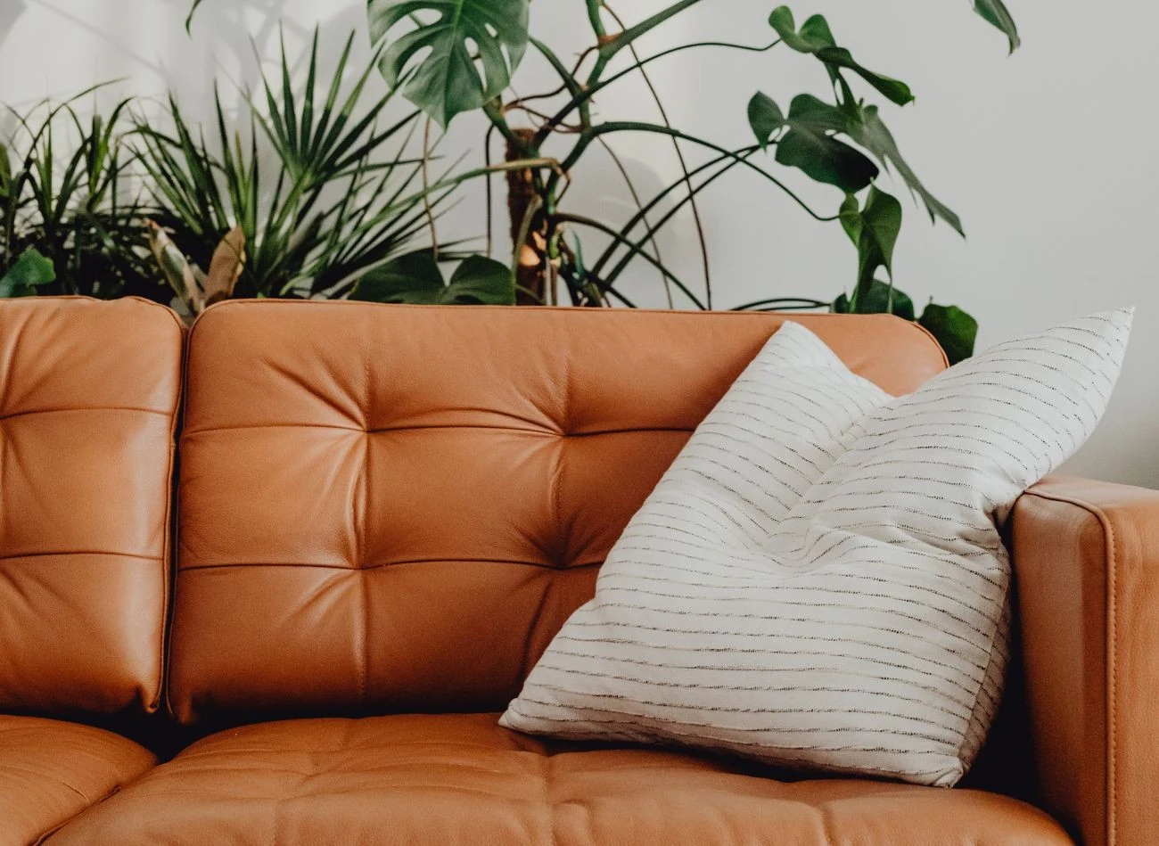 Skórzana kanapa w ciepłym, koniakowym odcieniu także po części wpisuje się w kanony stylu kolonialnego