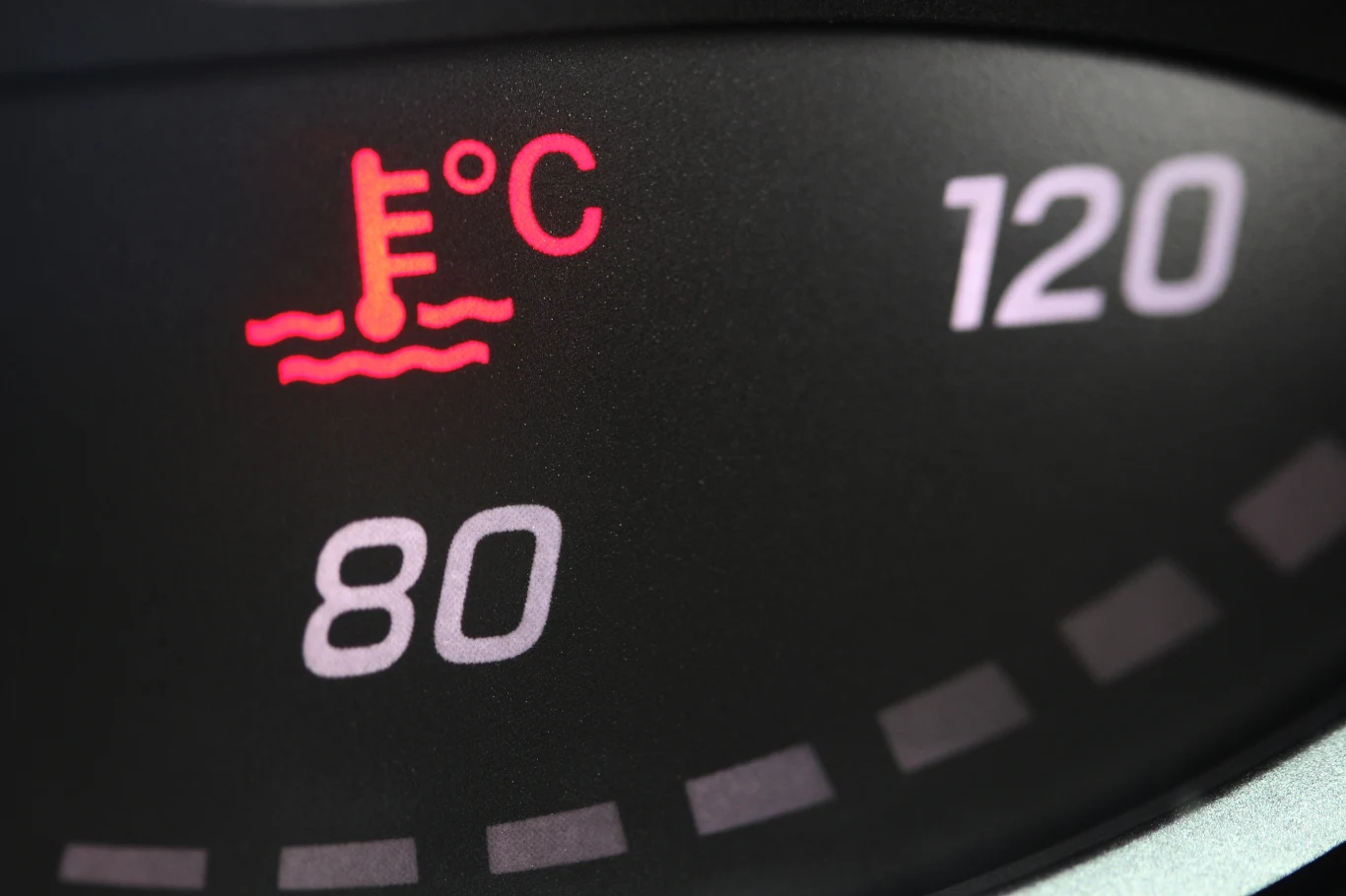 Dzisiaj lepiej nie zasłaniać domowymi sposobami chłodnicy. Może to doprowadzić do przegrzania silnika Zbliżenie wskaźnika temperatury cieczy chłodzącej w samochodzie z podświetloną na czerwono ikoną przegrzania oraz oznaczeniami skali temperatury w stopniach Celsjusza.
