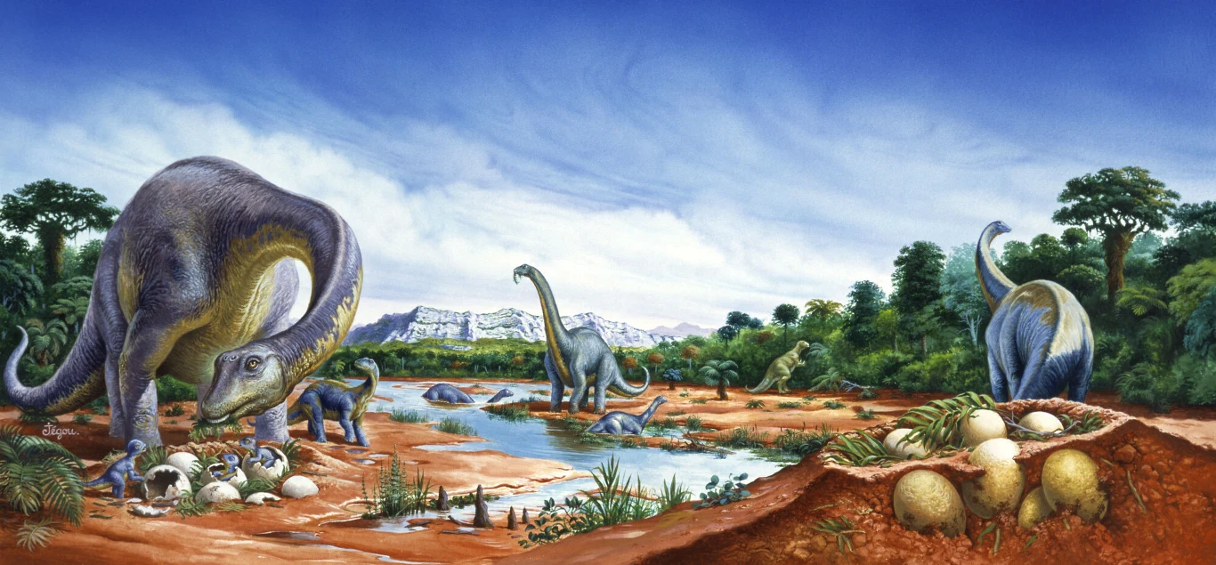Krajobraz prehistoryczny z dinozaurami w pobliżu wodopoju, kilka dużych dinozaurów spaceruje i opiekuje się jajami, w otoczeniu bujnej roślinności oraz widocznymi gniazdami z jajami na pierwszym planie, w tle widać wzgórza i błękitne niebo.