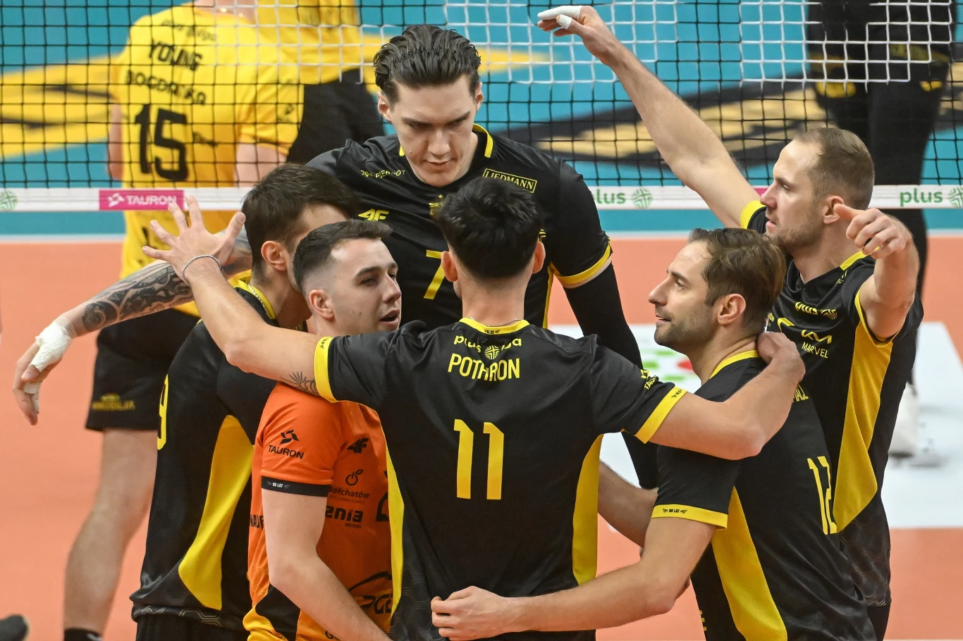 Siatkarze PGE GiEK Skry Bełchatów. Z numerem 7 Bartłomiej Lemański Siatkarze ubrani w czarno-żółte stroje świętują zdobyty punkt, obejmując się i podnosząc ręce w geście radości na boisku pod siatką
