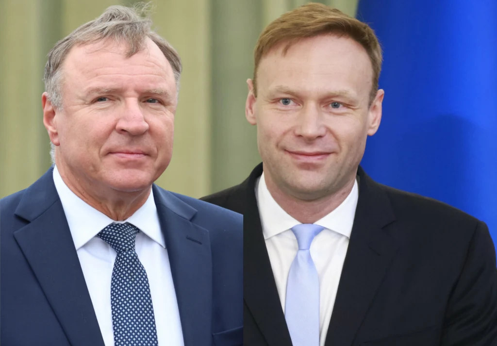 Jacek Kurski odpowiedział Marcinowi Mastalerkowi. "Dyżurny pajac" Dwóch mężczyzn w garniturach, jeden z niebieskim krawatem, drugi z jasnoniebieskim, stoi na tle zielonej zasłony oraz niebieskiego tła. Obaj mają poważny wyraz twarzy.