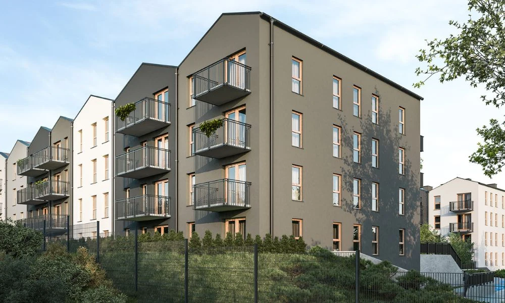 Nowoczesny lokal zamiast używanego z rabatem Nowoczesny budynek mieszkalny o kilku kondygnacjach, z licznymi balkonami i dużymi oknami, otoczony zielenią i ogrodzeniem, położony na delikatnym wzniesieniu, w tle widać inne podobne budynki.