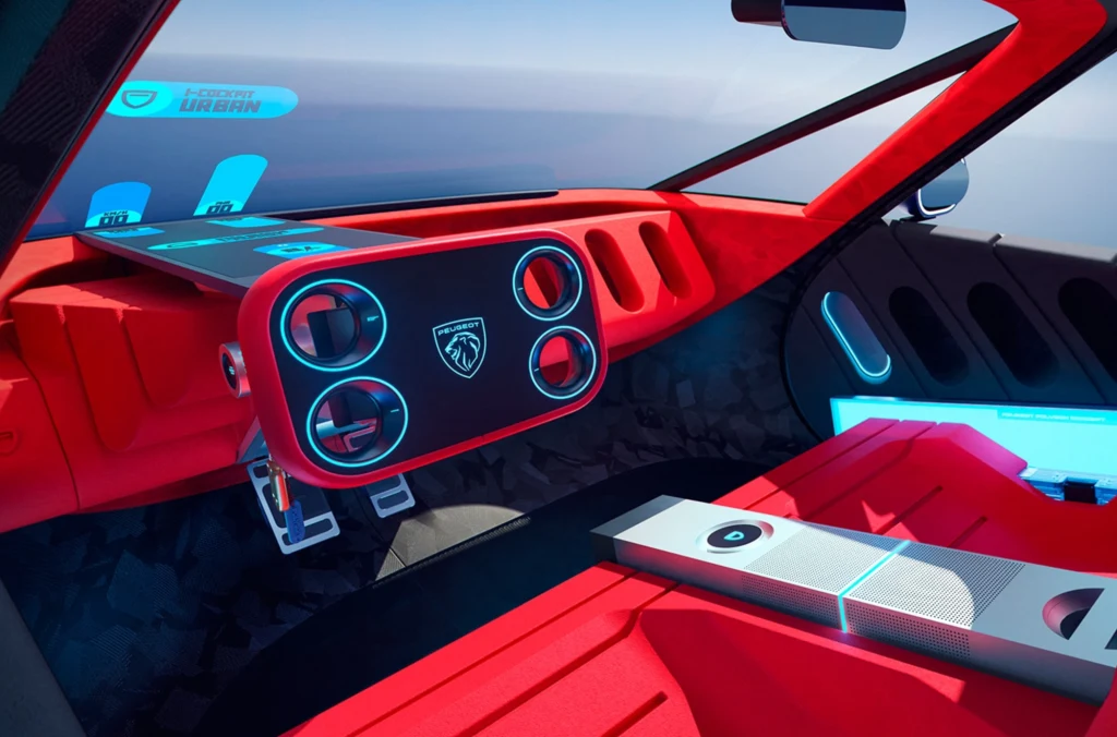 Wnętrze Polygona całkowicie odrzuca modę na duże ekrany dotykowe. Futurystyczne wnętrze samochodu koncepcyjnego z nowoczesną deską rozdzielczą, cyfrowymi wskaźnikami i wyraźnie zaznaczonymi czerwonymi oraz niebieskimi akcentami podświetlenia. Minimalistyczny wystrój wnętrza podkreśla zaawansowaną technologię pojazdu.