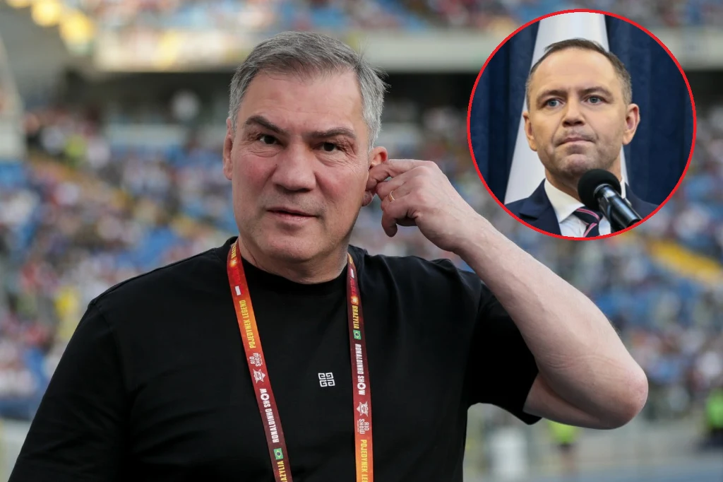 Mężczyzna w czarnej koszulce z akredytacją sportową na szyi stoi na stadionie, wykonując gest przykładający dłoń do ucha. W prawym górnym rogu widoczne wstawione okrągłe zdjęcie mężczyzny w garniturze przemawiającego przy mikrofonie.