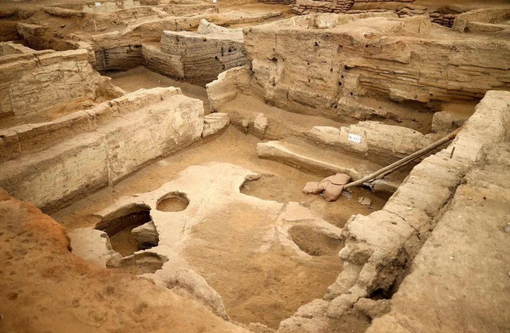 Wpisane na listę światowego dziedzictwa UNESCO stanowisko Çatalhöyük to jedno z najstarszych osiedli ludzkich na świecie. Wykopaliska archeologiczne z wyraźnie widocznymi warstwami ziemi i odsłoniętymi fragmentami dawnych murów; w centrum znajdują się narzędzia archeologiczne oraz niewielkie zagłębienia w ziemi, wskazujące na prace badawcze.