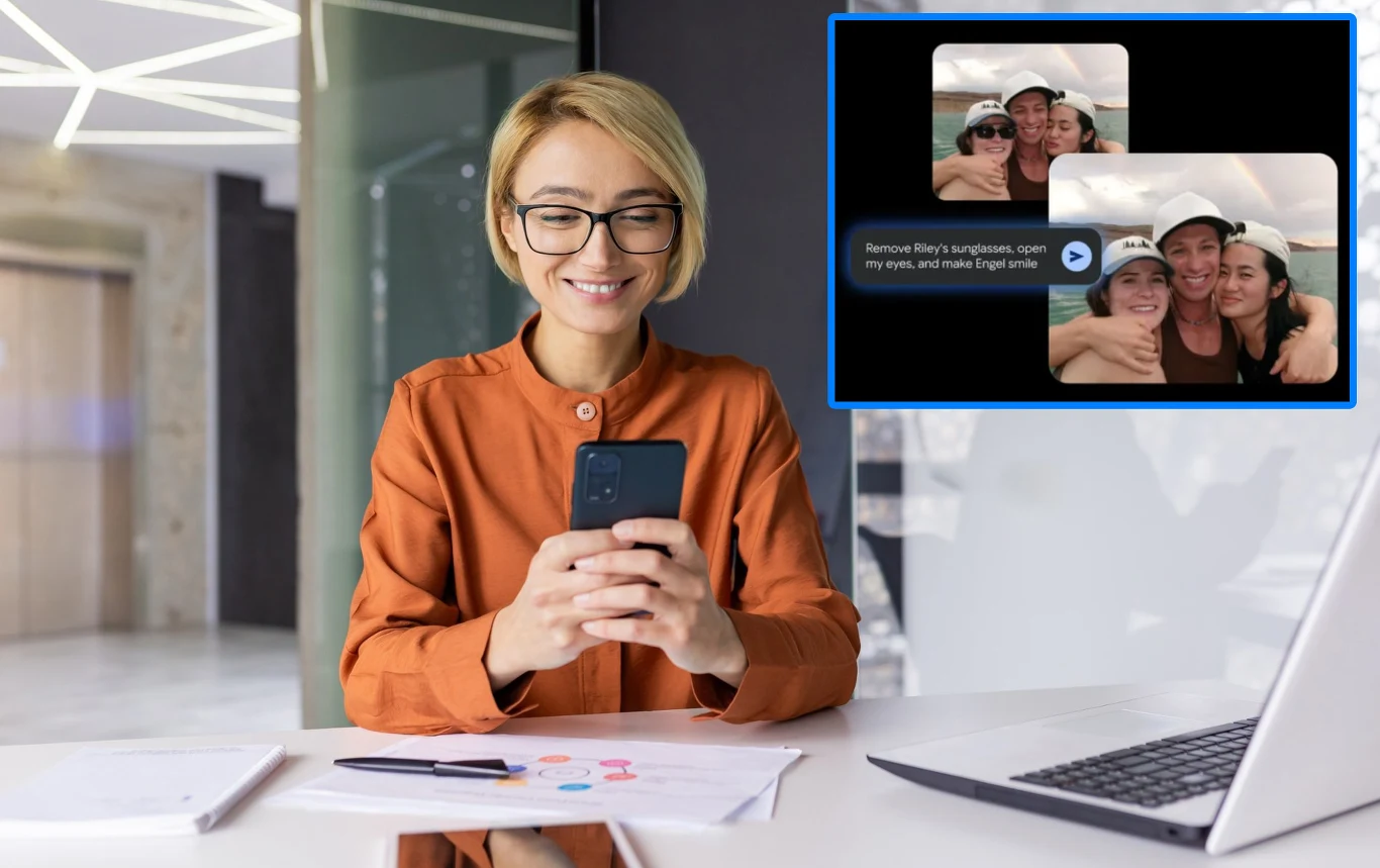 AI w Zdjęciach Google pomoże ci przerobić zdjęcia na Androidzie i iOS. Co potrafi Nano Banana? Kobieta z blond włosami nosząca okulary i pomarańczową koszulę siedzi przy biurku z dokumentami i laptopem, patrząc z uśmiechem na ekran swojego smartfona; w prawym górnym rogu widoczny jest powiększony zrzut ekranu z dwoma selfie osób w czapkach.