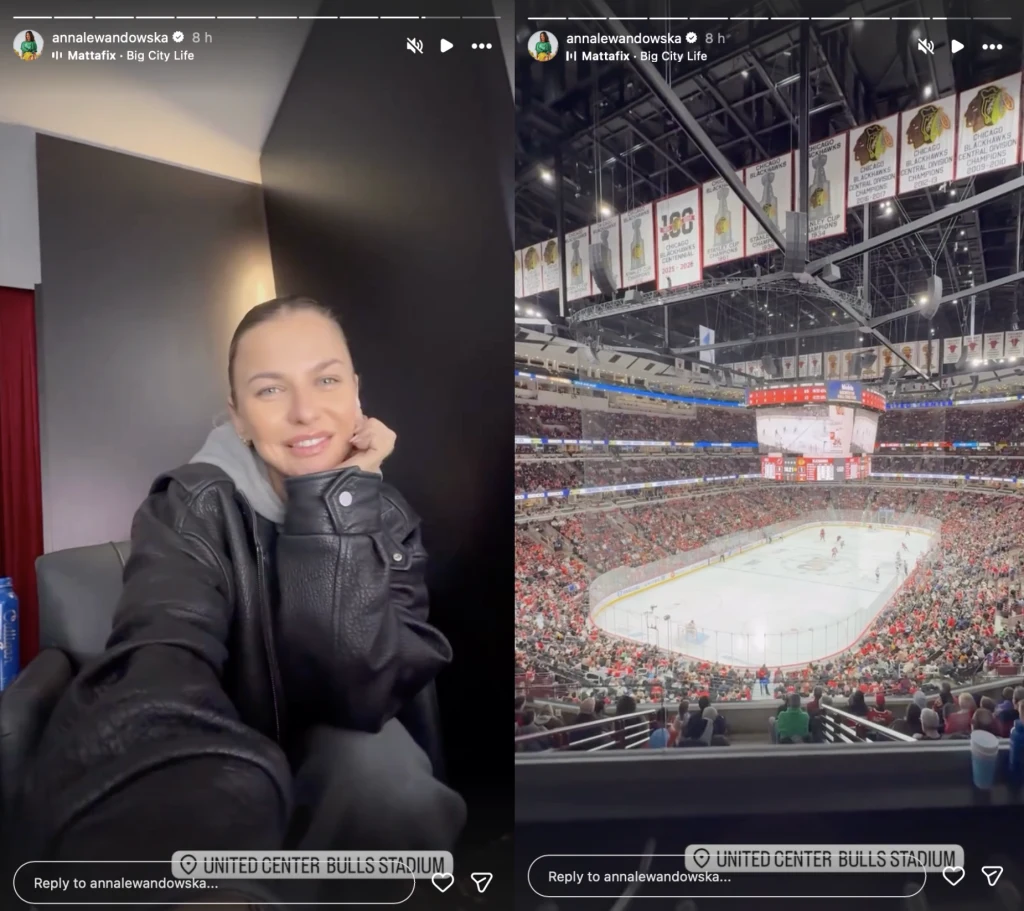 Kobieta ubrana w czarną kurtkę siedzi przy stoliku w zamkniętym pomieszczeniu, uśmiecha się do aparatu. Obok panorama hali sportowej z widokiem na lodowisko w trakcie meczu hokejowego, trybuny pełne kibiców, widoczny duży ekran nad taflą.