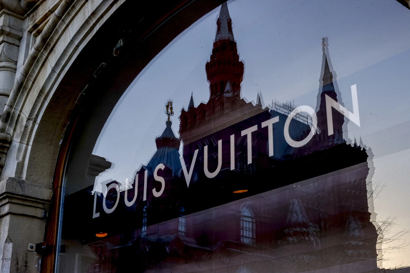 Światowe marki przed wojną uważały Moskwę za znakomite miejsce do robienie interesów Odbicie zabytkowej architektury z czerwonej cegły z charakterystycznymi wieżami w witrynie sklepu Louis Vuitton, napis widoczny na szkle.