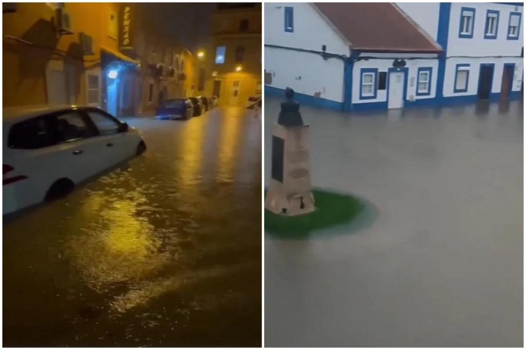 Zalane ulice miasta z unieruchomionymi samochodami oraz budynkami częściowo zanurzonymi w wodzie, ślady intensywnych opadów i powodzi utrudniające codzienne funkcjonowanie mieszkańców.