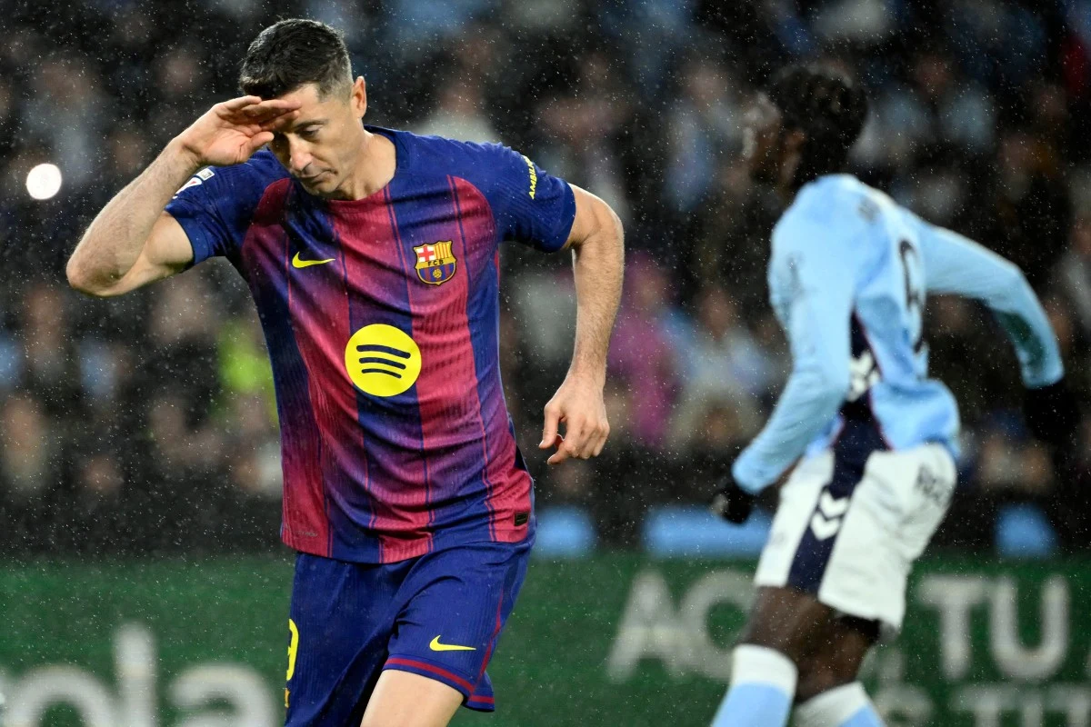 Robert Lewandowski zagra w Turcji? Są nowe informacje Piłkarz w koszulce FC Barcelony wykonuje gest ręką w geście radości po zdobyciu gola, w tle widoczny zawodnik drużyny przeciwnej w jasnoniebieskim stroju.