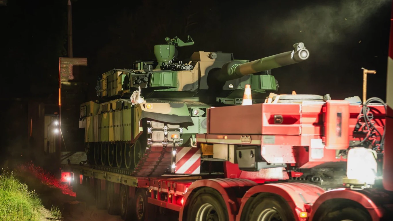 Kolejny transport czołgów K2GF dotarł do Polski. To już koniec umowy Czołg transportowany na ciężarówce nocą. Światła pojazdu oświetlają masywny wojskowy sprzęt, wokół panuje ciemność, a pojazd wojskowy ma dobrze widoczny, duży kaliber działa.
