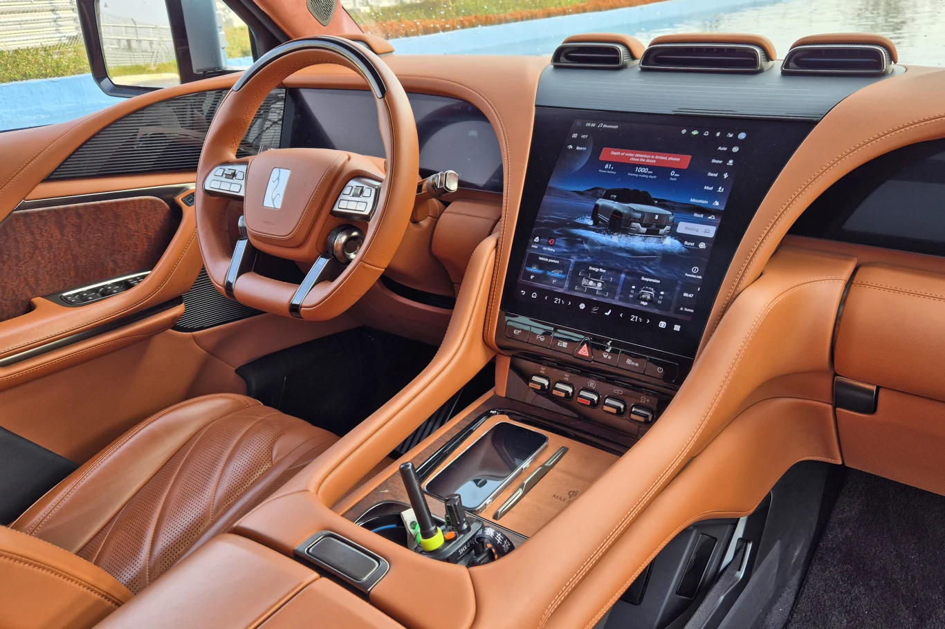 Yangwang U8 wyróżnia się luksusowo wykończonym wnętrzem Ekskluzywne wnętrze samochodu wykończone brązową skórą, nowoczesna konsola środkowa z dużym ekranem dotykowym, sportowa wielofunkcyjna kierownica i eleganckie panele ozdobne.