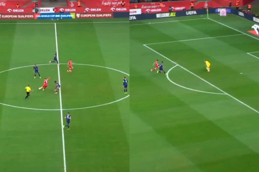 Gol Polski w meczu z Holandią Dwóch piłkarzy w czerwonych strojach i kilku zawodników w niebieskich koszulkach rywalizuje o piłkę na zielonym boisku, po lewej stronie sędzia w żółtej koszulce, w tle widoczne reklamy oraz fragmenty trybun, z prawej strony akcja kieruje się w stronę ...