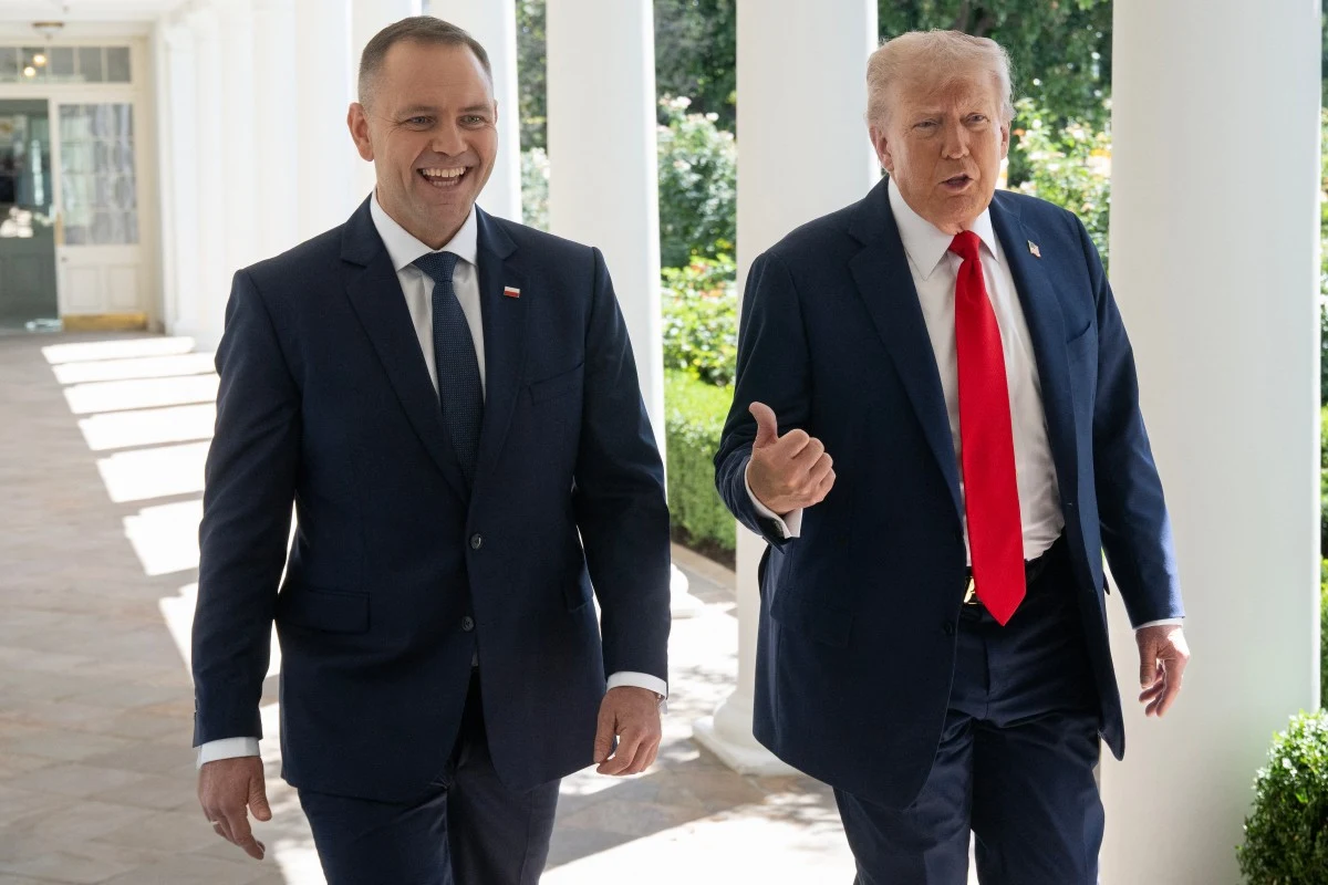 Prezydent Polski Karol Nawrocki i prezydent USA Donald Trump Dwóch mężczyzn ubranych w eleganckie garnitury idzie korytarzem na zewnątrz, obaj uśmiechnięci, jeden z nich gestykuluje, w tle kolumnada i zieleń ogrodu.