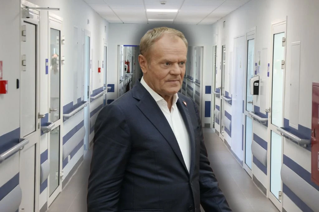 Dostaliśmy weto w składkę - mówił Tusk. Ale chyba spróbujemy jeszcze raz. Mężczyzna w garniturze idzie korytarzem szpitalnym, wnętrze jasne, ściany w biało-niebieskich barwach, nowoczesne drzwi po obu stronach korytarza.