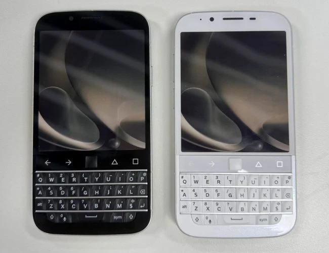 Dwa smartfony z fizyczną klawiaturą QWERTY, jeden w czarnej, a drugi w białej obudowie, obok siebie na jasnej powierzchni.