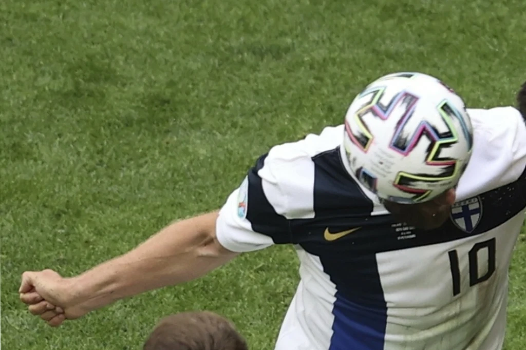 Teemu Pukki pożegnał się z reprezentacją Finlandii Piłkarz w białej koszulce z numerem 10 wykonuje uderzenie głową piłki na tle zielonej murawy podczas meczu piłkarskiego; elementy stroju wskazują na grę drużynową, widoczna połowa sylwetki.