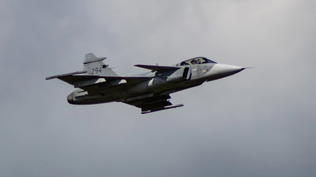 Gripeny dla Kolumbii zagrożone? Zainterweniować może sam Donald Trump Myśliwiec wojskowy z numerem 294 lecący na tle pochmurnego nieba, widoczna kabina pilota i charakterystyczne oznaczenia na kadłubie.