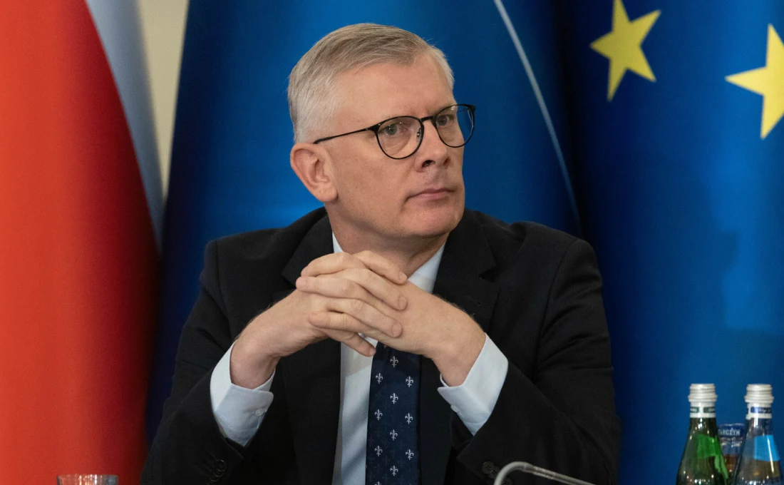 Sławomir Cenckiewicz uderzył w polityków PiS po wyborze Włodzimierza Czarzastego na marszałka Sejmu Mężczyzna w garniturze i okularach siedzi przy stole konferencyjnym, ma splecione dłonie, w tle widoczne są flagi Polski oraz Unii Europejskiej i stojące na stole butelki wody.