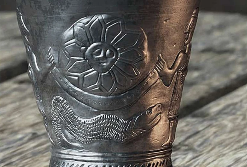 Archeolodzy zaskoczeni. Starożytny kielich może kryć historię kosmosu Fragment starożytnego metalowego naczynia ozdobionego reliefem z wizerunkiem stylizowanego kwiatu, ludzkiej postaci i węża, całość utrzymana w szarościach z wyraźnym detalem rzeźbień.