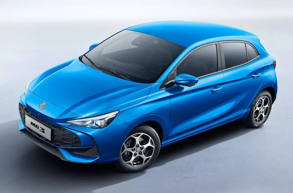 MG3 wyróżnia się najmocniejszą jednostką napędową w zestawieniu - to silnik 1.5 o mocy 115 KM. Niebieski samochód osobowy typu hatchback o nowoczesnym designie, stojący na jasnym tle. Wyposażony w pięcioro drzwi, charakterystycznie ukształtowane reflektory i aluminiowe felgi z pięcioma ramionami.