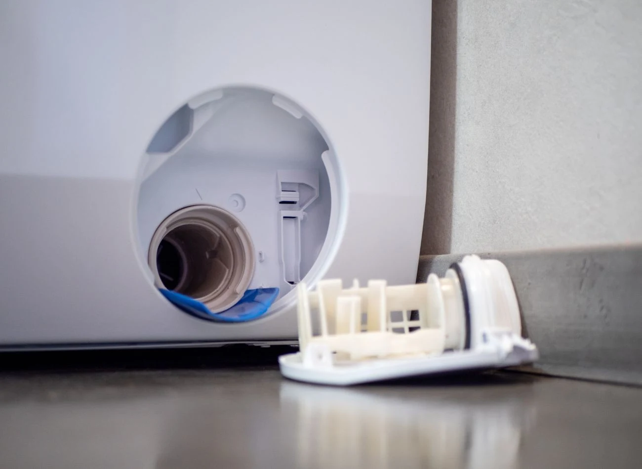 Filtr w pralce trzeba najpierw odkręcić, a później przemyć bieżącą wodą.