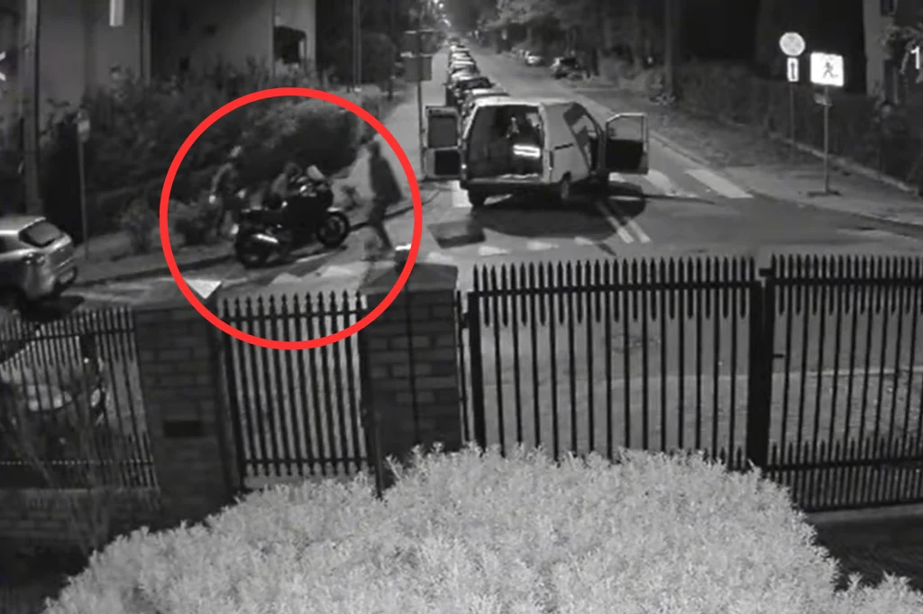 Złodzieje ukradli motocykl w Legionowe. Trwało to zaledwie minutę. Ulica nocą oświetlona lampami, zaparkowany skuter oraz dostawczy samochód z otwartymi drzwiami, obok których kręci się kilka osób, całość uchwycona przez kamerę monitoringu.