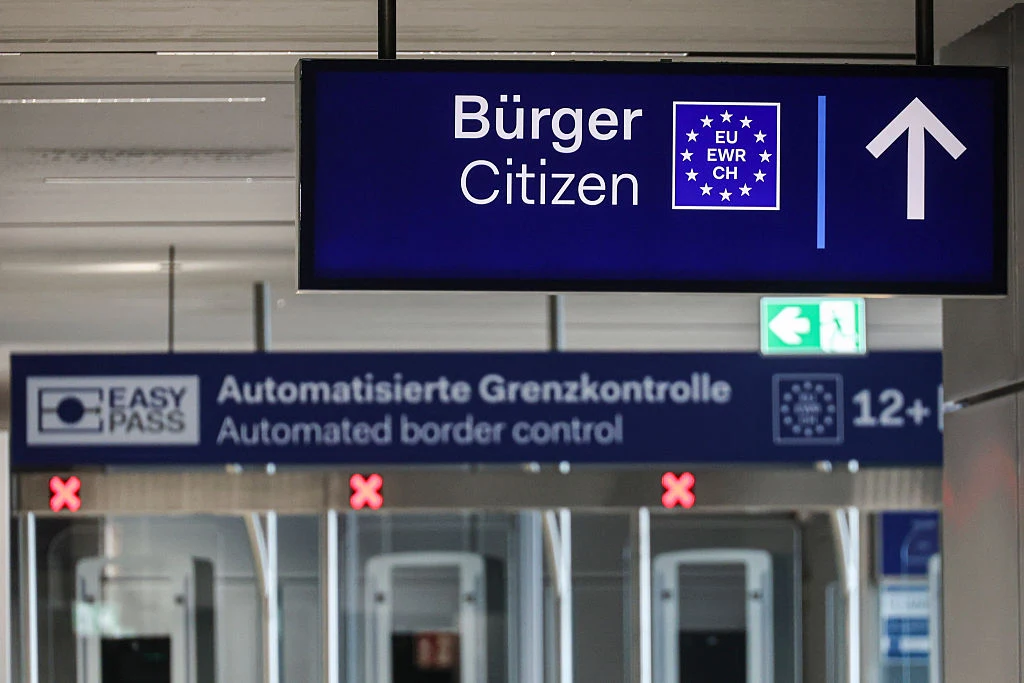 Kontrola paszportowa na lotnisku w Dusseldorfie w Niemczech Tablice informacyjne dotyczące obywateli Unii Europejskiej, Europejskiego Obszaru Gospodarczego oraz Szwajcarii, a także stanowiska do automatycznej kontroli granicznej z systemem EasyPASS. Strzałka kierująca do odpowiedniej strefy oraz oznaczenia doty...