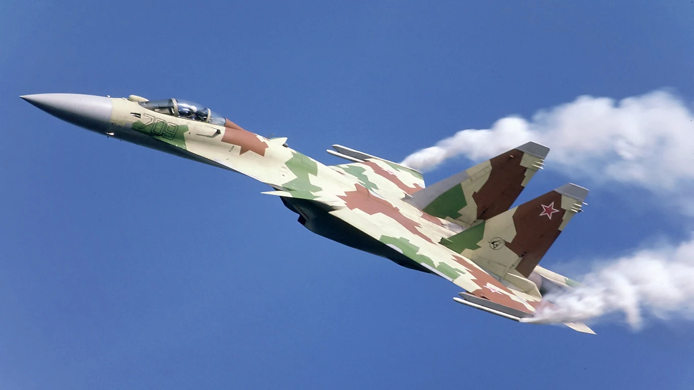 Rosjanie zestrzelili własny myśliwiec Su-35 za 85 mln dolarów Myśliwiec wojskowy w kamuflażu, unoszący się na tle błękitnego nieba z widocznymi strugami kondensacyjnymi wydobywającymi się z końcówek skrzydeł. Charakterystyczna czerwona gwiazda na stateczniku pionowym.