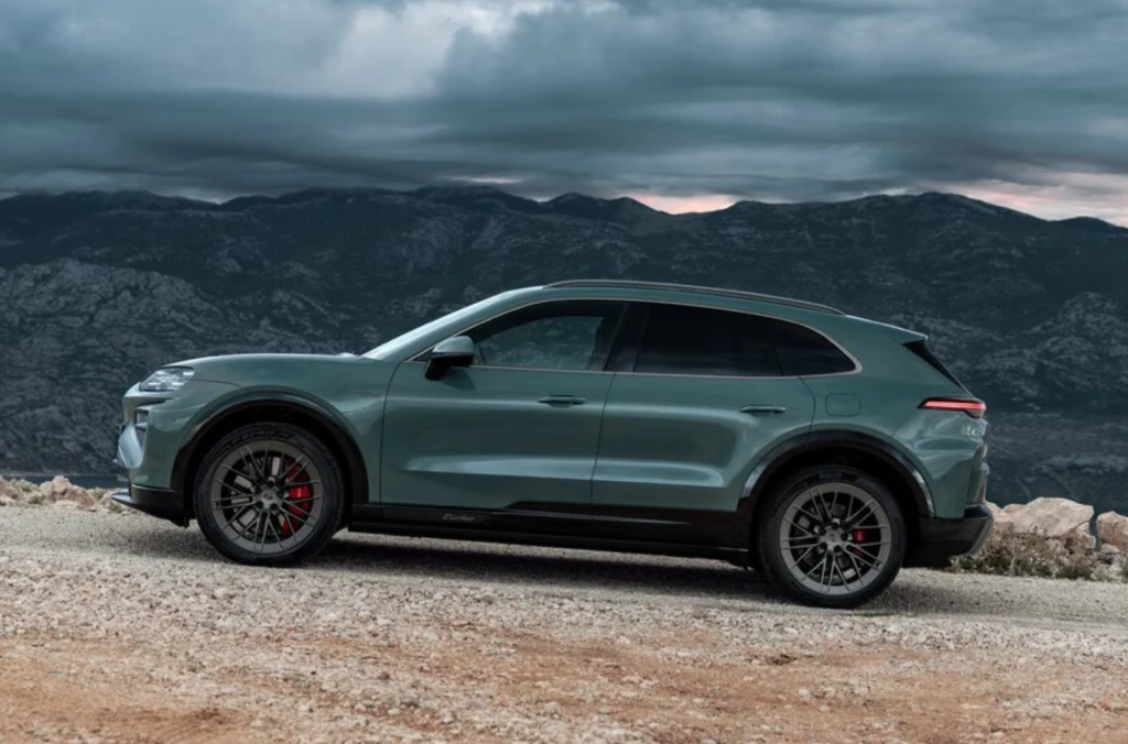 Luksusowy SUV w kolorze szarym zaparkowany na żwirowej drodze w otoczeniu górskiego krajobrazu pod pochmurnym niebem