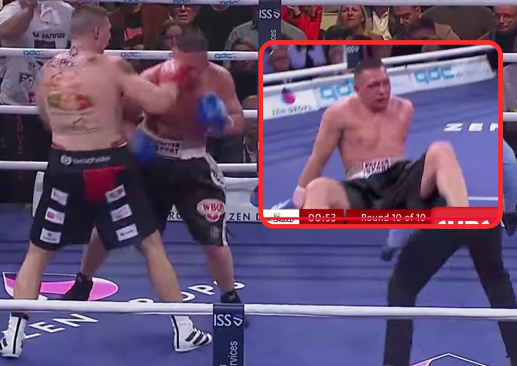 Mateusz Tryc w walce z Nickiem Hannigiem, którą wygrał efektownie przed czasem. Czy tak samo zdoła pokonać kolejnego przeciwnika z Niemiec, Artura Reisa? Pojedynek już w najbliższą sobotę Dwóch bokserów walczących na ringu podczas pojedynku, jeden zawodnik zadaje cios przeciwnikowi. W prawym górnym rogu widoczna zbliżona scena, w której drugi bokser leży na macie, zrezygnowany po otrzymanym ciosie. Publiczność obserwuje walkę.