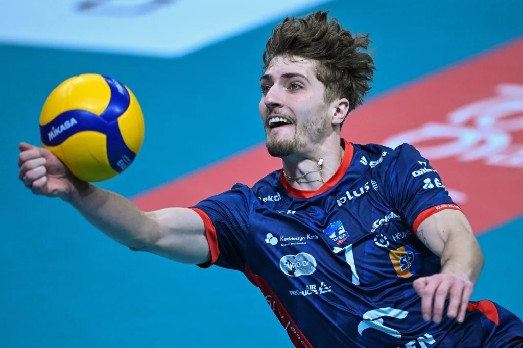 Igor Grobelny został wybrany MVP spotkania Asseco Resovia Rzeszów - ZAKSA Kędzierzyn-Koźle Siatkarz w niebieskim stroju drużynowym dynamicznie rzuca się, wyciągając rękę po piłkę podczas meczu siatkówki na hali sportowej, wyrazisty wyraz twarzy pokazuje skupienie i determinację.