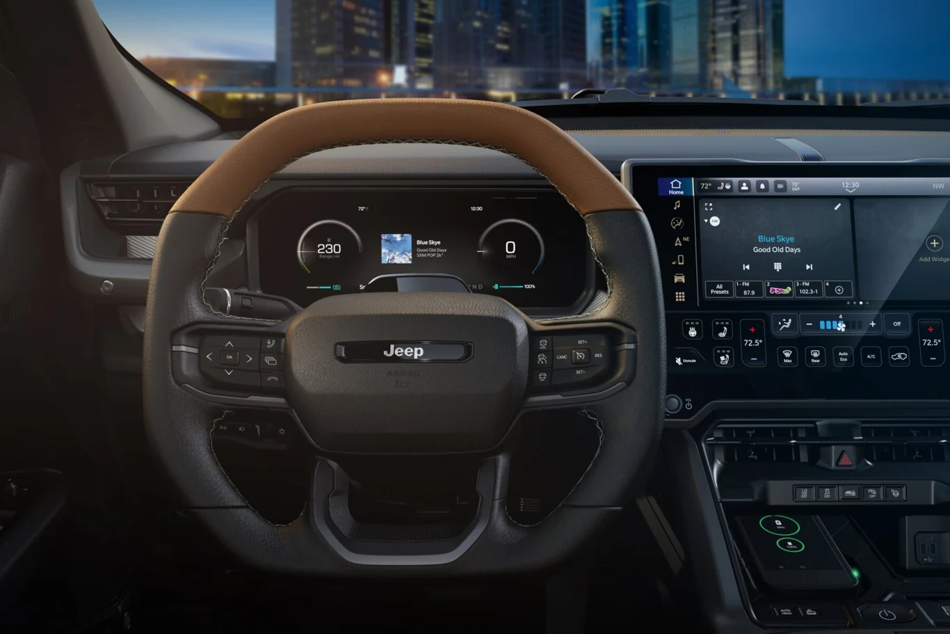 Nowoczesna deska rozdzielcza samochodu Jeep z wyraźnie widocznym kierownicą wykończoną brązową skórą, cyfrowymi zegarami oraz dużym ekranem dotykowym systemu multimedialnego. W tle rozmazane światła miasta.