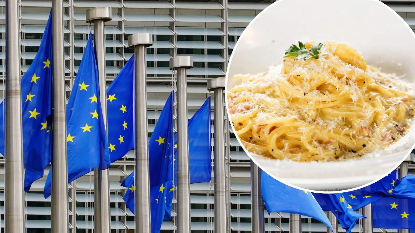 Włoski minister rolnictwa: Zażądałem natychmiastowego wszczęcia dochodzenia w PE Rząd flag Unii Europejskiej ustawiony przed nowoczesnym budynkiem, w rogu zdjęcia okrągłe wstawienie z talerzem makaronu carbonara, posypanego startym serem i udekorowanego gałązką pietruszki.
