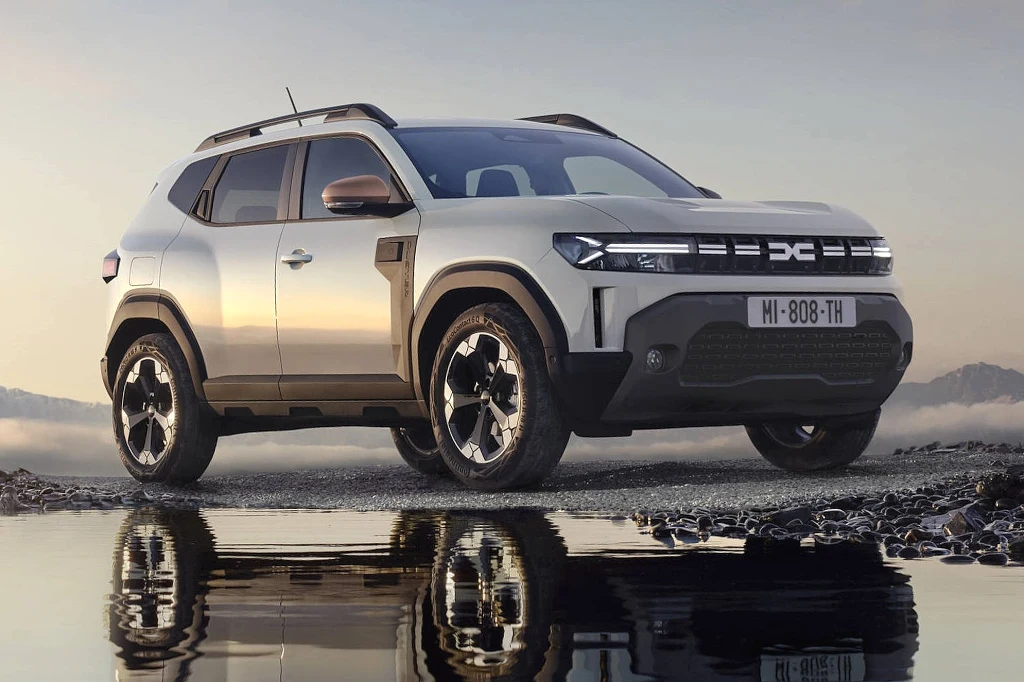Dacia Duster hybrid-G 150 4x4 Biały nowoczesny SUV stoi na podmokłym terenie odbijając się w wodzie, wokół rozciągają się delikatne mgły i widoczne są odległe wzgórza.