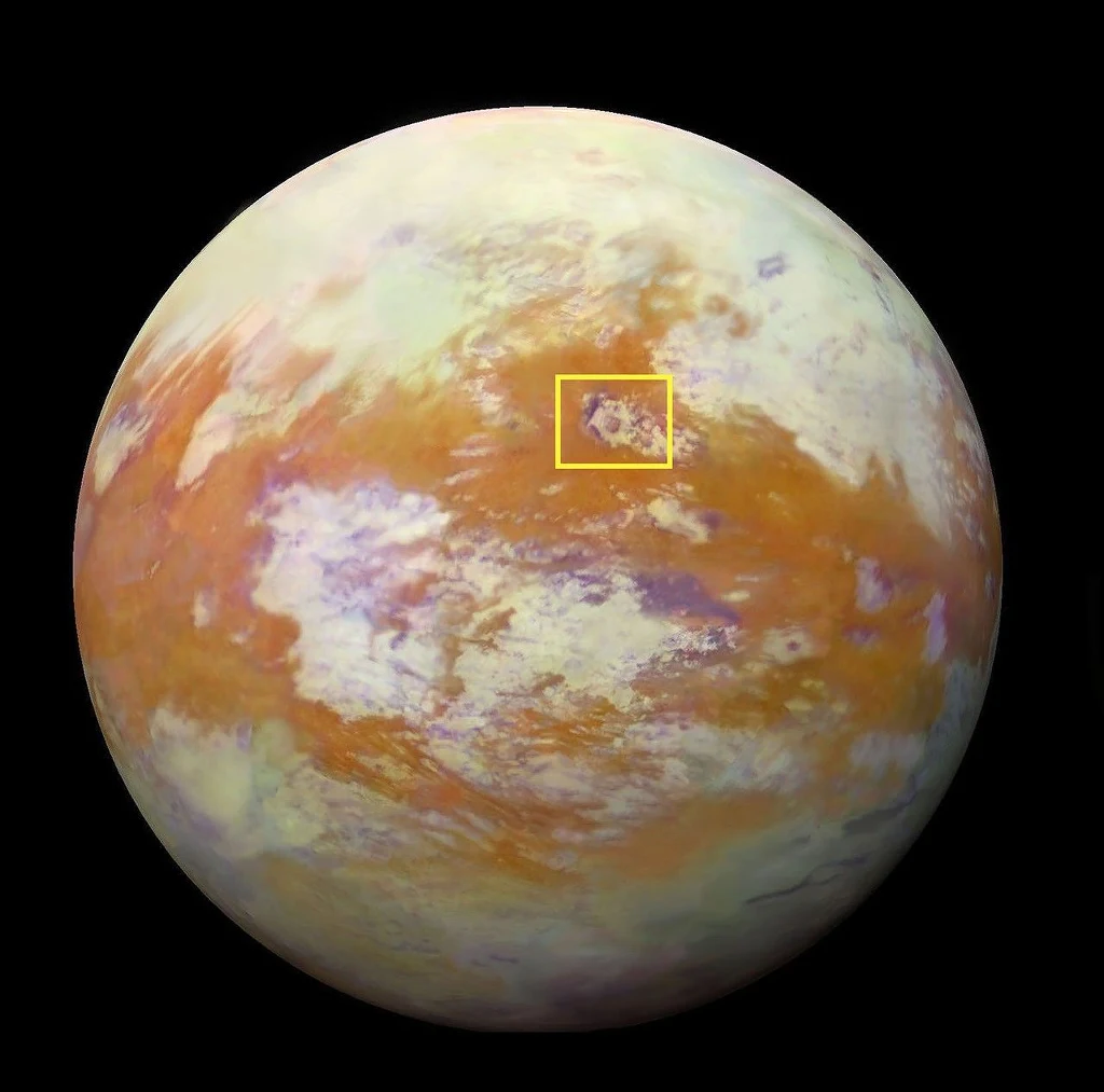 Kula o powierzchni pokrytej żółto-brązowo-fioletowymi wzorami, na tle czarnego kosmosu, z zaznaczeniem konkretnego obszaru prostokątem.