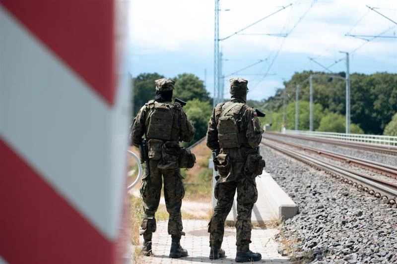 Akcja "Horyzont" ruszyła. Weźmie w niej udział 10 tys. żołnierzy Dwóch umundurowanych żołnierzy z wyposażeniem wojskowym stoi przy torach kolejowych na tle zielonych drzew i nieba, po lewej stronie kadru widoczny jest fragment czerwono-białego słupa granicznego.