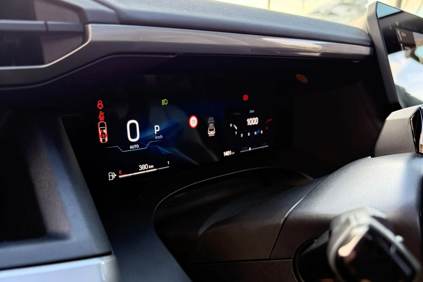 Cyfrowy wyświetlacz deski rozdzielczej samochodu prezentuje wskaźniki prędkości, poziomu paliwa, stanu drzwi oraz różnych systemów bezpieczeństwa oraz informacji dla kierowcy.