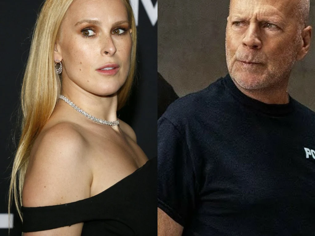 Rumer Willis, Bruce Willis Portret dwóch dorosłych osób, kobiety w eleganckiej, czarnej sukni i mężczyzny w czarnym T-shircie z napisem na ramieniu, ustawionych obok siebie na neutralnym tle.