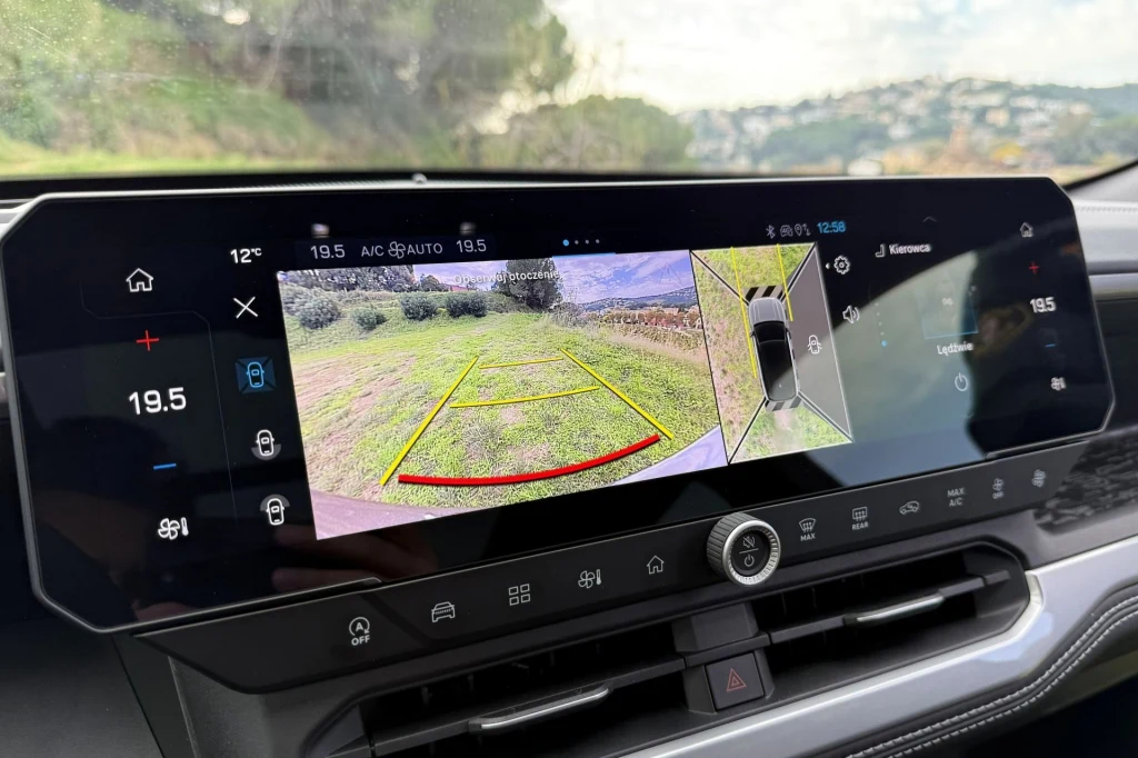Jakość obrazu z kamer jest na całkiem niezłym poziomie. Wyświetlacz samochodowy pokazujący obraz z kamery cofania oraz grafikę asystenta parkowania z wyznaczonymi liniami cofania i widocznym widokiem tylnego otoczenia auta.