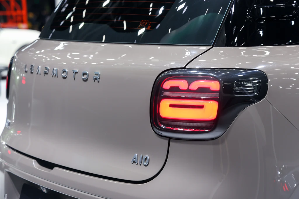 Tylna część jasnego samochodu elektrycznego marki Leapmotor z wyraźnie widocznymi światłami tylnymi oraz oznaczeniami modelu A10