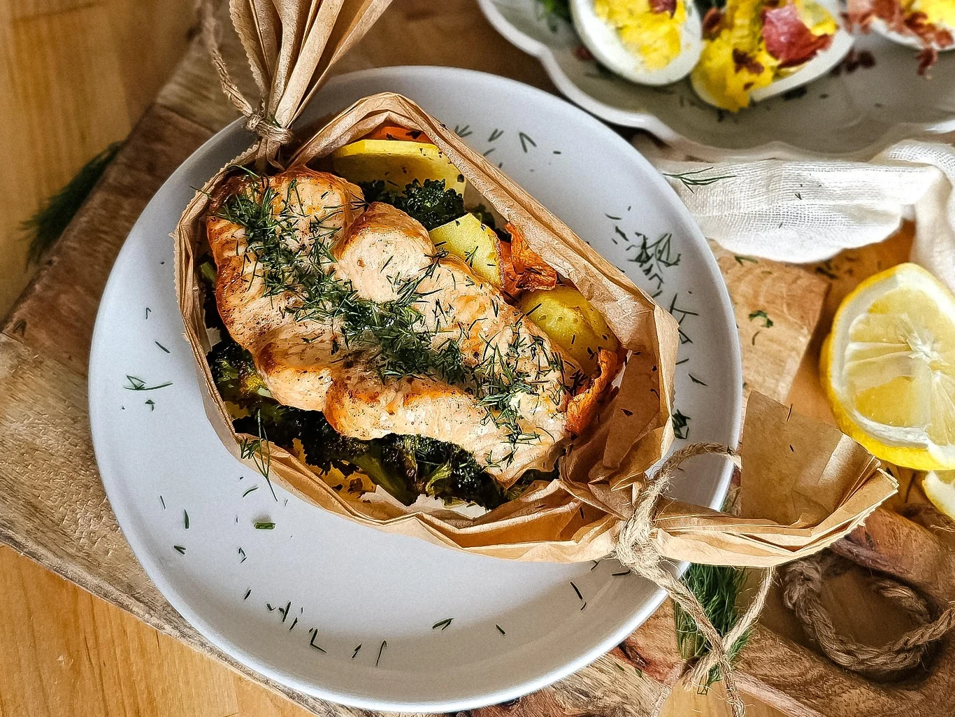 Łososia kroimy na grube steki, nacinamy je pośrodku, doprawiamy sola i pieprzem, układamy na warzywach