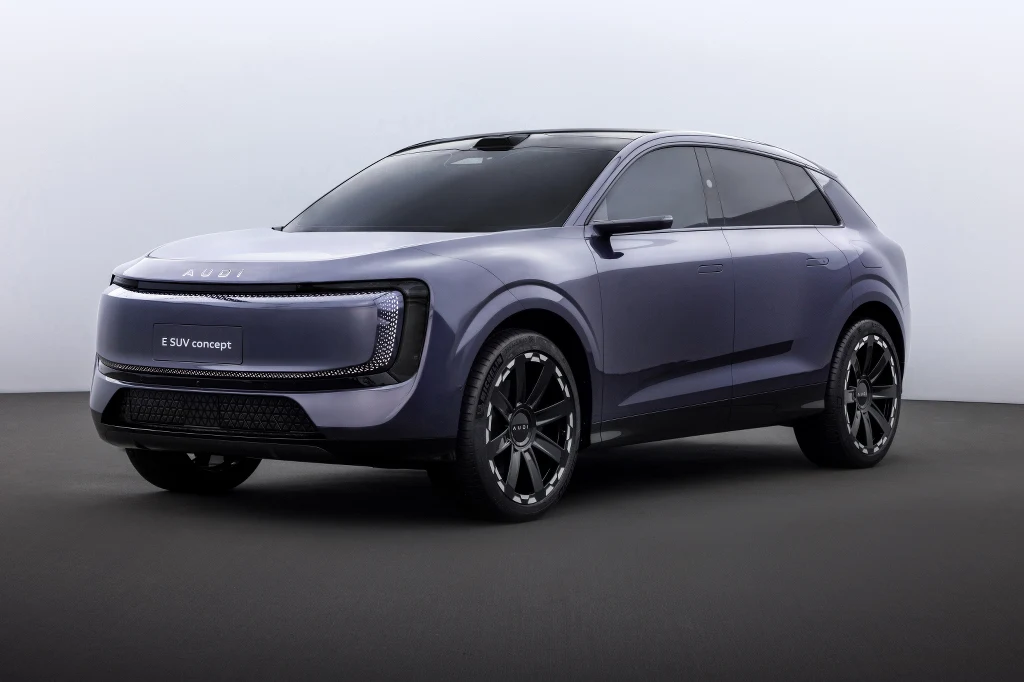 Fioletowy nowoczesny SUV z przyciemnianymi szybami, dynamiczną sylwetką i dużymi felgami, osadzony na ciemnym tle z minimalistycznym napisem modelu na grillu.