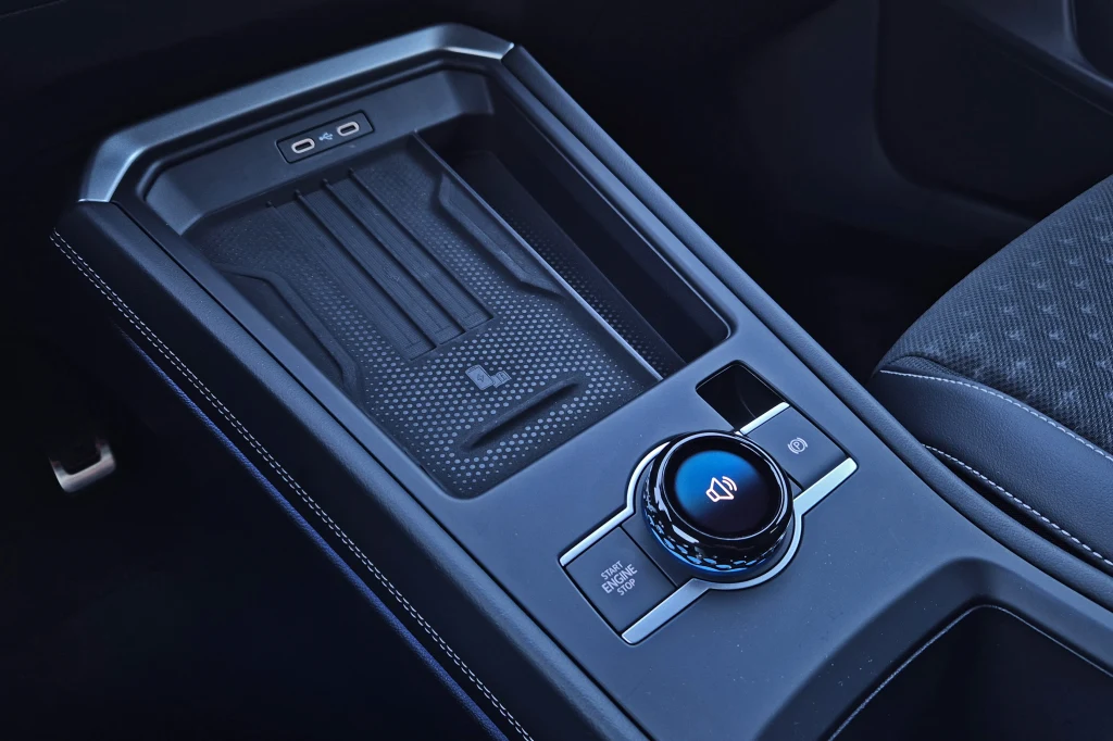 Centralne pokrętło z wyświetlaczem znamy już z Tiguana - pozwala na regulację głośności oraz zmianę trybów jazdy Konsola centralna samochodu z nowoczesnym panelem sterowania, pokrętłem głośności oraz miejscem na drobne przedmioty.