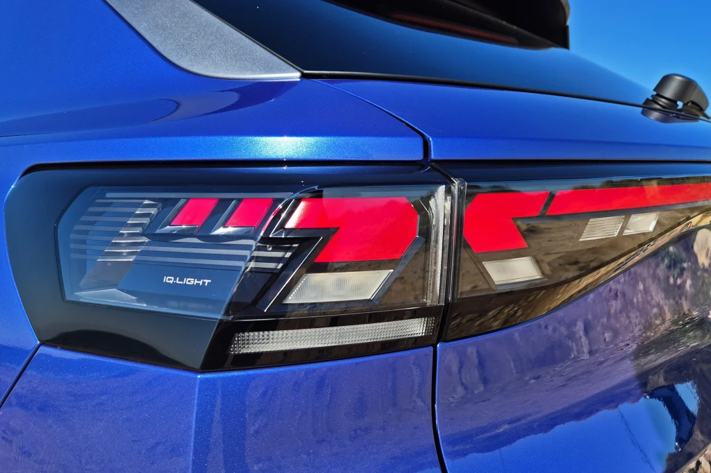 Volkswagen T-Roc Tylna lampa samochodu z nowoczesnym wzorem świateł LED i oznaczeniem IQ.LIGHT na niebieskim lakierze karoserii.