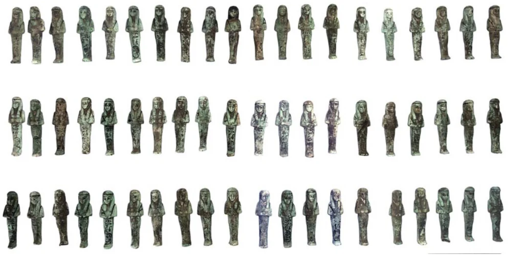 Szereg niewielkich, stylizowanych figurek w różnych odcieniach zieleni, ułożonych w czterech rzędach na białym tle. Wszystkie figurki mają podobny kształt i posturę, różnią się drobnymi szczegółami i kolorami.